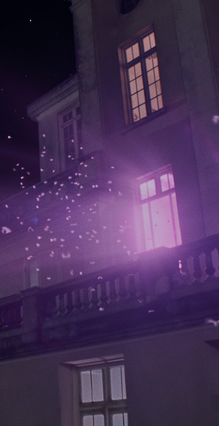 Moths flock across the night sky toward the top of a mansion. From the living room window, the camera cuts to a silhouette of a couple watching TV on the sofa. Bands of blue and
purple light sway onscreen.